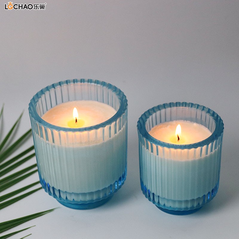 How do you properly extinguish a scented candle to avoid black smoke or shattering glass?